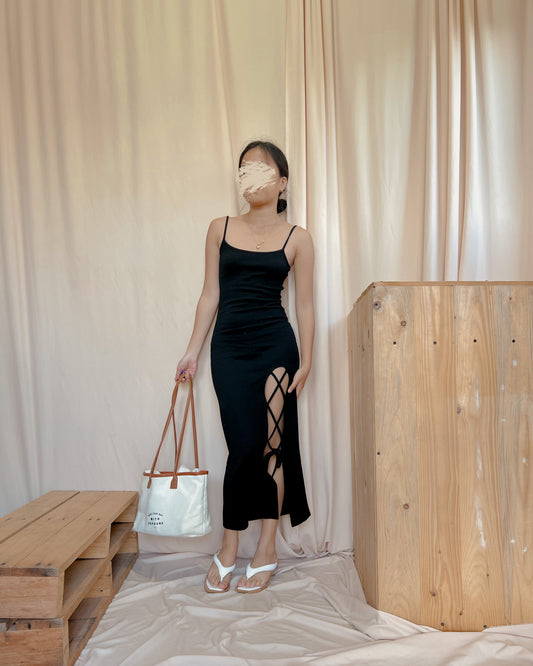 black body hugging dress with “x” slit