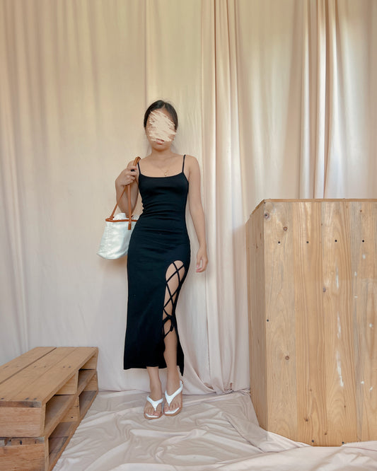 black body hugging dress with “x” slit